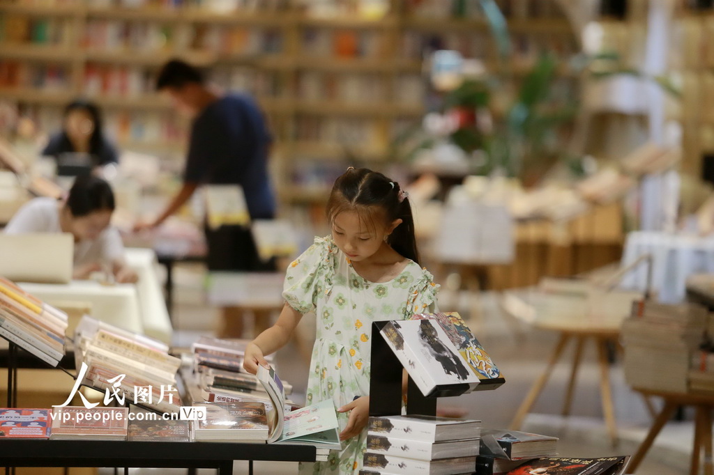 7月22日，小朋友在江苏扬州的钟书阁书店内读书纳凉。