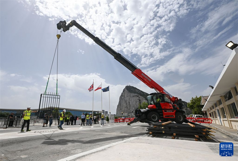 7月15日，在直布罗陀与西班牙拉利内阿－德拉康塞普西翁之间的陆路边境口岸，吊车将围栏吊起拆除。 新华社记者 程敏 摄